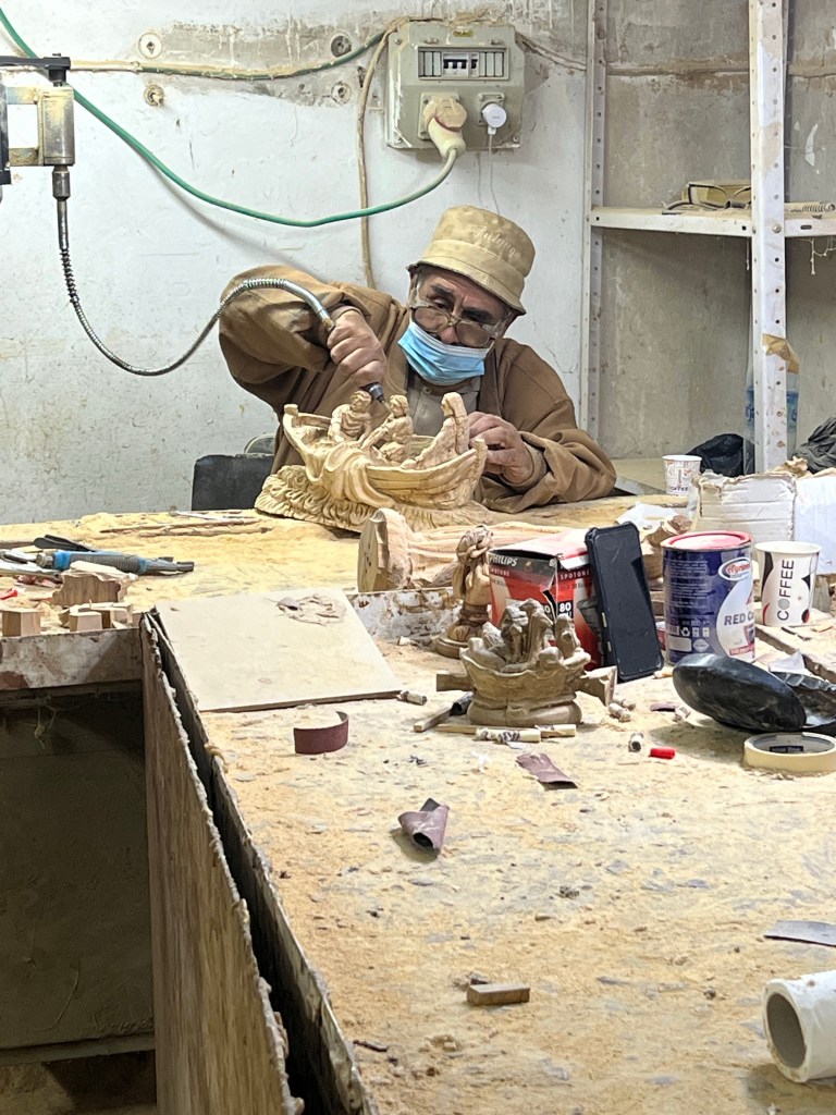 Watching a Christian artist create a Biblical scene out of olive wood.